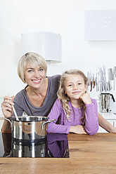 Germany, Bavaria, Munich, Mother and daughter preparing food, smiling, portrait - RBYF000306