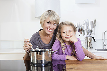 Germany, Bavaria, Munich, Mother and daughter preparing food, smiling, portrait - RBYF000307