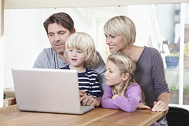 Germany, Bavaria, Munich, Family using laptop, smiling - RBYF000309