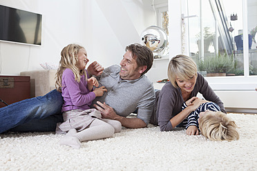 Germany, Bavaria, Munich, Family having fun on floor - RBYF000322