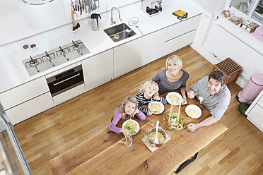 Deutschland, Bayern, München, Familie isst Spaghetti in der Küche - RBYF000325