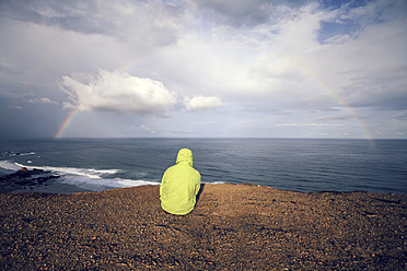 Portugal, Young man sitting at Praia do Castelejo - WVF000293