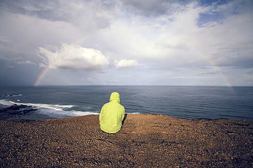 Portugal, Junger Mann sitzt am Praia do Castelejo - WVF000293