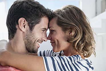 Spanien, Mid adult couple embracing each other in modern apartment - WESTF018917