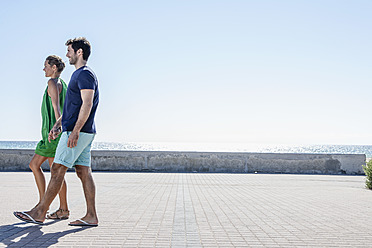 Spanien, Mittleres erwachsenes Paar beim Gehen auf dem Bürgersteig - WESTF018966