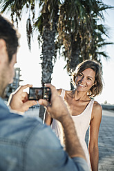 Spanien, mittelgroßer erwachsener Mann fotografiert eine Frau - WESTF018971