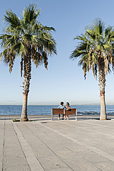 Spanien, Mittleres erwachsenes Paar auf Bank sitzend - WESTF018972
