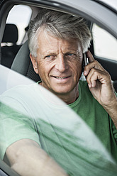 Spain, Senior man sitting in car and talking on phone - WESTF019040