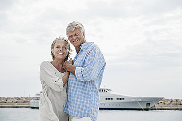 Spain, Senior couple at harbour, smiling, portrait - WESTF019044