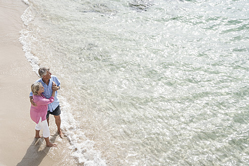Spanien, Seniorpaar am Strand stehend - WESTF019065