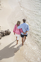 Spanien, Seniorenpaar geht am Strand spazieren - WESTF019067