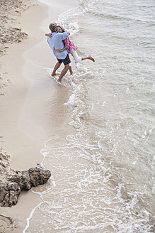 Spanien, Seniorenpaar in Umarmung am Strand - WESTF019073