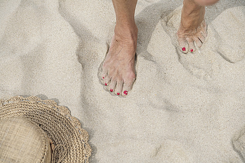 Spanien, Ältere Frau geht am Strand spazieren - WESTF019086