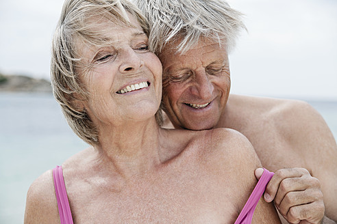 Spanien, Älteres Paar entkleidet sich am Strand - WESTF019093