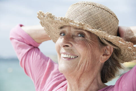 Spain, Senior woman with straw hat, smiling stock photo