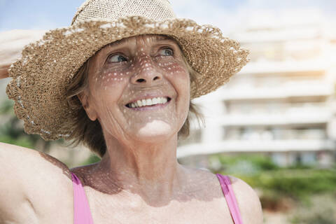 Spain, Senior woman with straw hat, smiling stock photo