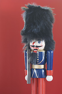 Close up of Nutcracker figurine against red background - ASF004676