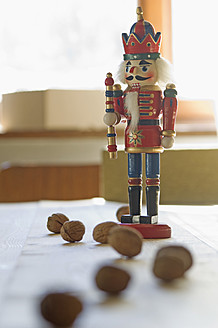 Nutcracker figurine with walnuts on table - ASF004679