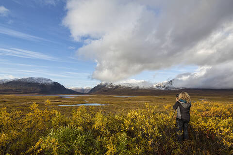 USA, Alaska, Tourist beim Fotografieren der Alaska Range im Herbst, lizenzfreies Stockfoto