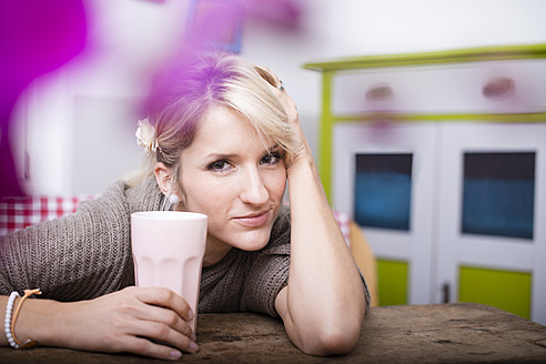 Portrait of young woman sitting at table with coffee - VRF000084