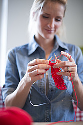 Young woman knitting with red yarn - VRF000099