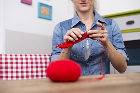 Young woman knitting with red yarn - VRF000101