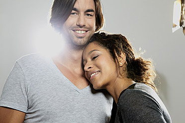 Close up of couple against gray background, smiling - FMKF000483