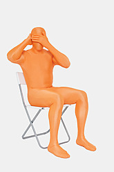 Älterer Mann in orangefarbenem Zentai mit Händen, die die Augen bedecken - TCF003047
