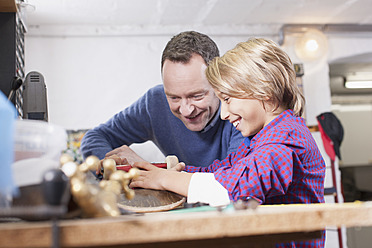 Deutschland, Leipzig, Vater und Sohn reparieren Skateboard - BMF000577