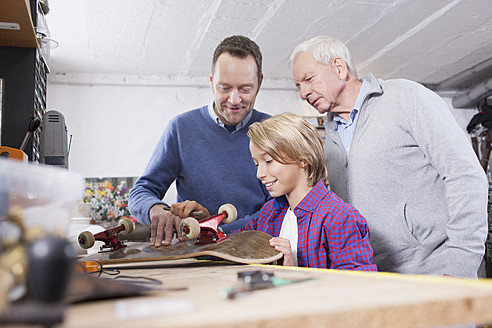 Deutschland, Leipzig, Großvater, Vater und Sohn reparieren Skateboard - BMF000580