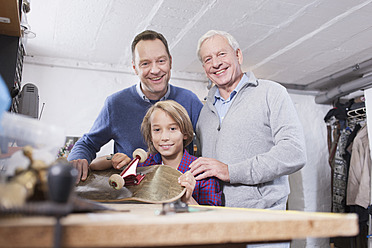 Deutschland, Leipzig, Großvater, Vater und Sohn reparieren Skateboard - BMF000581