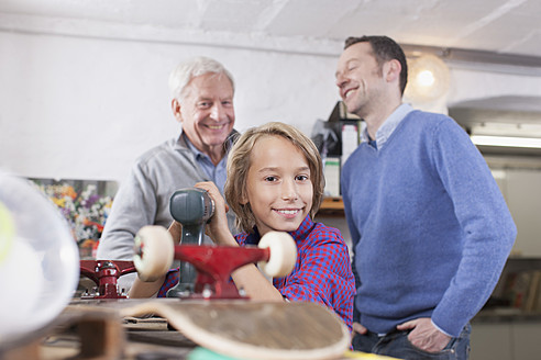 Deutschland, Leipzig, Großvater, Vater und Sohn reparieren Skateboard - BMF000589