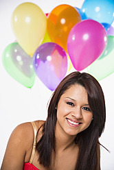 Portrait of young woman with balloons, smiling - ABAF000390
