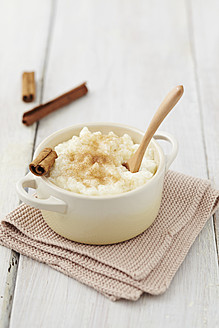 Milk rice pudding in pot with cinnamon on table - ECF000160