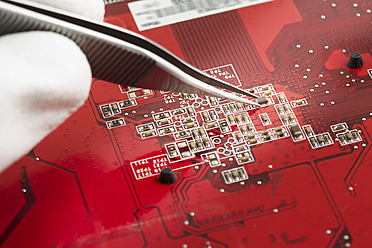 Human hand repairing printed circuit board, close up - DSCF000002