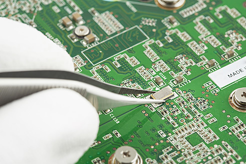 Human hand repairing printed circuit board, close up - DSCF000003