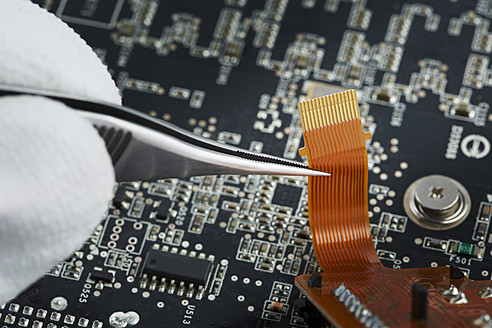 Human hand repairing printed circuit board, close up - DSCF000009