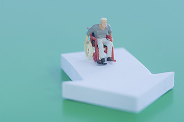 Figur im Rollstuhl mit Pfeilzeichen auf grünem Hintergrund - ASF004684