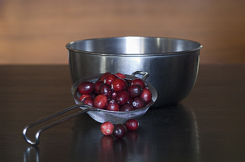 Preiselbeeren im Sieb mit Schüssel auf dem Tisch - ASF004689