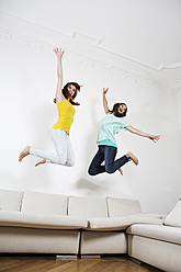 Deutschland, Berlin, Junge Frauen haben Spaß und springen auf der Couch - SKF001018