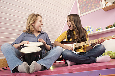Mädchen spielen Gitarre und Schlagzeug, lachen - RNF001090