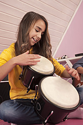 Mädchen spielt Schlagzeug, lächelnd - RNF001053