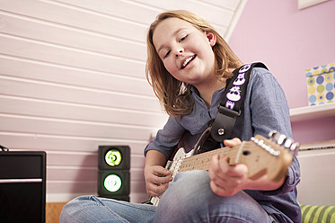 Girl playing guitar, smiling - RNF001059