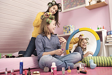 Mädchen mit Lockenwicklern tragen Make-up auf - RNF001095