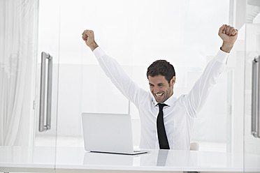 Spain, Businessman excited while looking laptop, smiling - PDYF000314