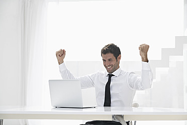 Spain, Businessman excited while looking laptop, smiling - PDYF000319