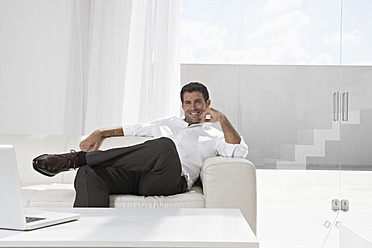 Spanien, Geschäftsmann entspannt auf Couch - PDYF000364
