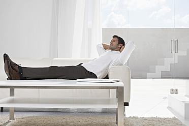 Spanien, Geschäftsmann entspannt auf Couch - PDYF000367