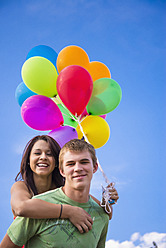 USA, Texas, Teenager, der eine junge Frau Huckepack nimmt, lächelnd - ABAF000481