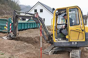 Europa, Deutschland, Rheinland-Pfalz, Älterer Mann mit Aushubfahrzeug zur Vorbereitung des Fundaments - CSF015982